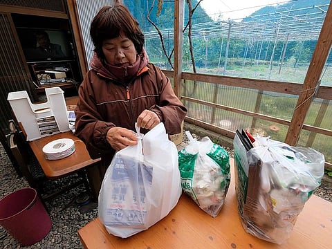 Japanese resident Saeko Takahashi sorting trash at her home kitchen in the town of Kamikatsu, Tokushima prefecture.