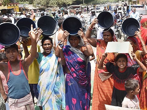 People block a road in protest demanding supply of potable water during a hot summer day in Patna