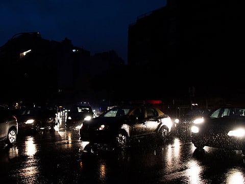 Cars drive through an unlit street during a blackout in Buenos Aires, Argentina, Sunday, June 16, 2019.