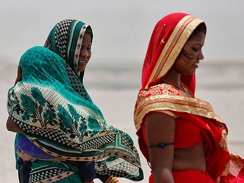 Women cover themselves as they walk during a dust storm on a hot day in Prayagraj, India, Sunday, June 16, 2019. Many parts of India are experiencing extreme heat conditions.