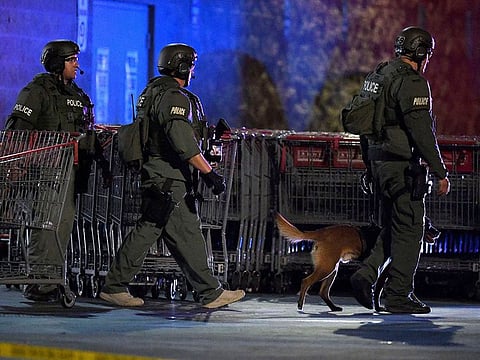 Heavily armed police officers exit the Corona Costco following a shooting inside the wholesale warehouse in Corona, Calif., Friday, June 14, 2019.