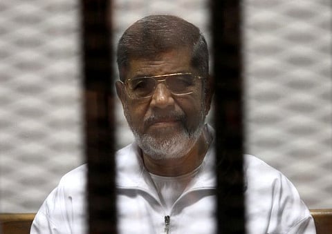 Ousted Egyptian President Mohamed Mursi is seen behind bars during his trial at a court in Cairo May 8, 2014.