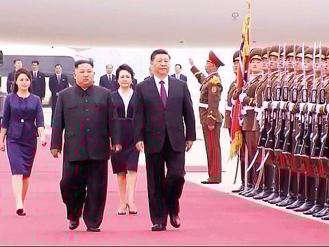 North Korean leader Kim Jong-un, left, and Chinese President Xi Jinping, right, walk together on Xi's arrival at an airport in Pyongyang, on Thursday, June 20, 2019.