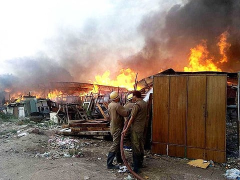 Firefighters try to douse fire at a furniture market near Kalindi Kunj station, in New Delhi