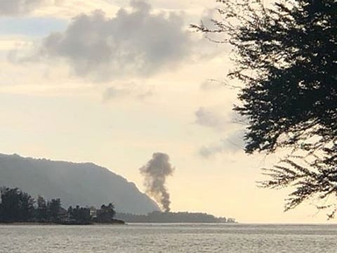 A plume of smoke rises after an airplane crash in Haleiwa, Hawaii, U.S., June 21, 2019 in this image obtained from social media.