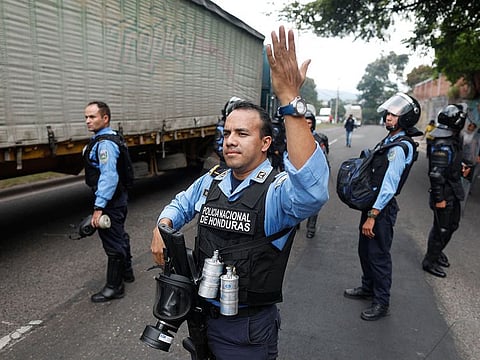 Riot police allow traffic through during a day of protests in Tegucigalpa, Honduras, Friday, June 21, 2019.
