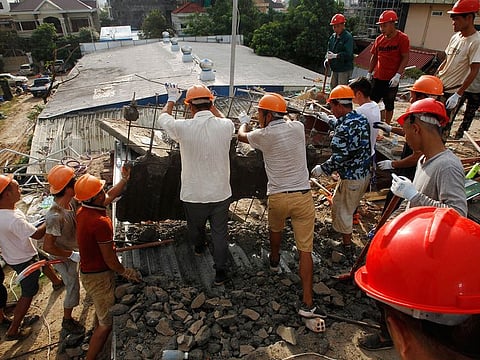 Rescue workers recover a body from the rubble of a collapsed building in Preah Sihanouk province, Cambodia Saturday, June 22, 2019.