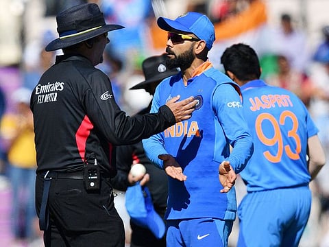 India's captain Virat Kohli (C) speaks with the umpire during the World Cup group stage match against Afghanistan at the Rose Bowl in Southampton.