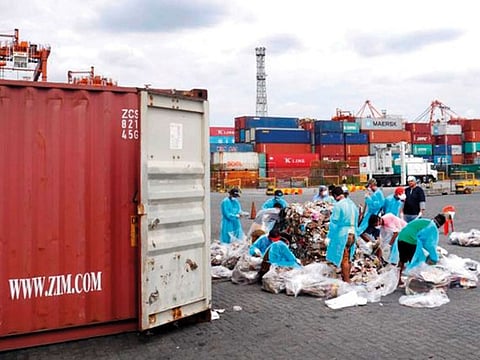 A file photo of Philippine customs officials inspecting cargo containers containing tonnes of garbage shipped by Canada.
