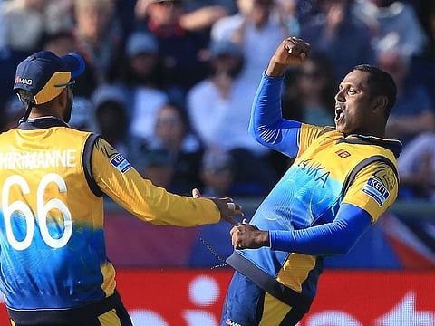 Sri Lanka's Angelo Mathews (R) celebrates with teammate Lahiru Thirimanne after the dismissal of West Indies' Nicholas Pooran.