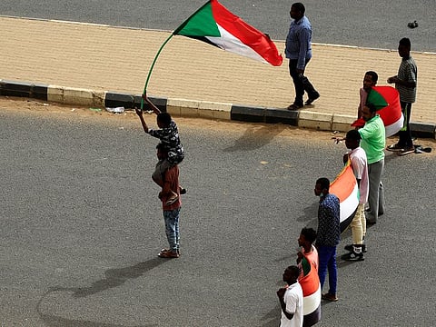 Sudanese stand on a road blocked by security forces during a demonstration demanding the ruling military hand over to civilians in Khartoum, Sudan, June 30, 2019.