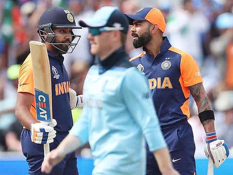 England's captain Eoin Morgan, centre, walks past India's Virat Kohli, right, and Rohit Sharma during the World Cup match between them at Edgbaston in Birmingham.