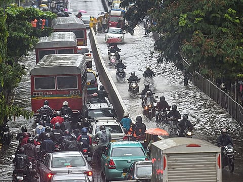Vehicles move slowly through waterlogged streets during heavy monsoon rain, in Mumbai.