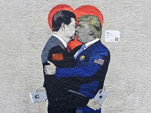 A mural entitled 'Smart Love' by Italien street artist TvBoy is displayed on a wall in Milan, which depicts China's President Xi Jinping (L) holding an i-Phone smartphone kissing US President Donald Trump holding an Huawei smartphone.
