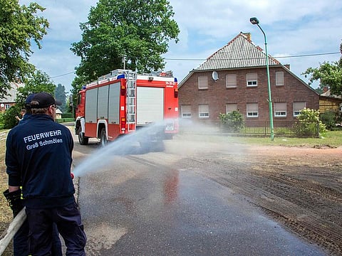 Firefighters splash water in the evacuated locality of Alt Jabel in order to keep the area wet, as a huge forest blaze rips through a former military training area in Mecklenburg-Western Pomerania, northern Germany, on July 2, 2019. The former military training ground near the town of Luebtheen is littered with bombs, grenades and bullets from the Nazi era's Wehrmacht, the former Soviet army, and from reunited Germany's Bundeswehr. Hundreds of emergency personnel, backed by helicopters, army vehicles and police water canon, have been fighting the flames and evacuated four nearby villages with a total of over 1,000 residents in Mecklenburg-Western Pomerania state.