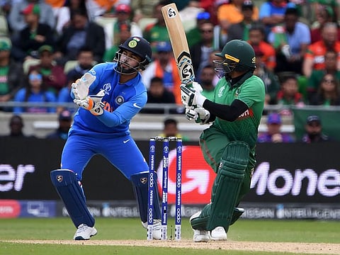 India's Rishabh Pant (L) takes on role as wicket-keeper for a few overs during the group stage match against Bangladesh at Edgbaston in Birmingham.