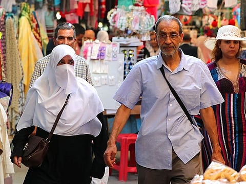 A woman, wearing a face veil, walks in the old city of Tunis, Tunisia.