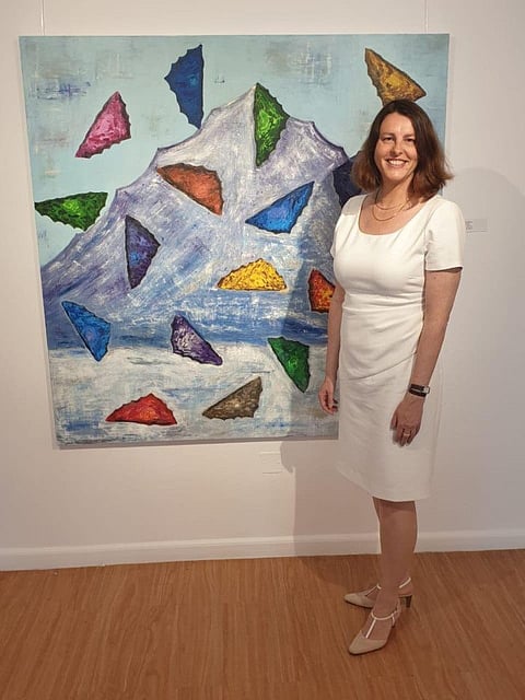 nathalie beras - image of artist with her painting - the butterfly islands at the opening