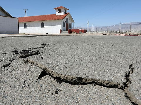 Cracks are seen in the street next to Trona Community Church after a powerful magnitude 7.1 earthquake broke, triggered by a 6.4 the previous day, near the epicenter in Trona, California.
