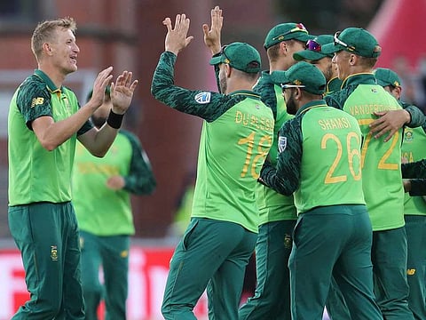 South Africa's Chris Morris, left, celebrates with teammates after dismissing Australia's Alex Carey during the Cricket World Cup match between Australia and South Africa at Old Trafford in Manchester, England, Saturday, July 6, 2019.