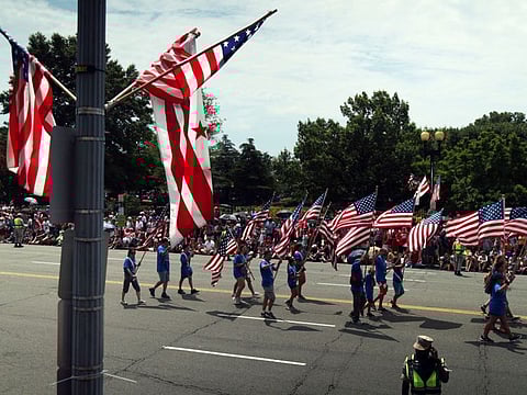 Marchers hold US flags during the National Independence Day Parade on July 4, 2019 in Washington, DC.