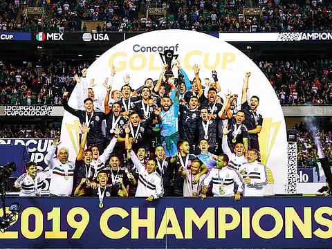 Mexico players and coaches celebrate with the Gold Cup after beating the US during the 2019 Concacaf Gold Cup final football match on July 7, 2019 at Soldier Field stadium in Chicago, Illinois.