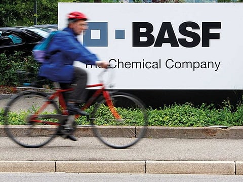 File photo: A cyclist rides his bike past the entrance of the BASF plant and former Ciba production site in Schweizerhalle near Basel, Switzerland.