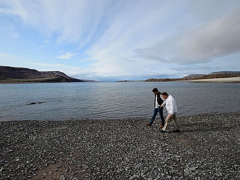 Canadian Prime Minister Justin Trudeau and PJ Akeeagok, president of the Qikiqtani Inuit Association, walk the shore of Pamiuja as they visit Arctic Bay, Nunavut, Thursday, Aug. 1, 2019.