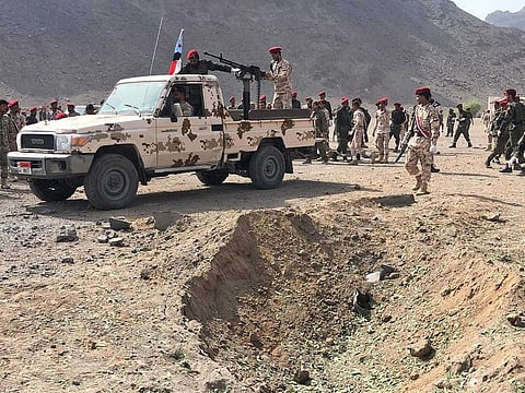 Yemeni security forces rush to the scene of a missile attack on a military camp west of Yemen's government-held second city Aden