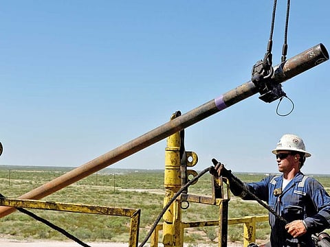 A drilling crew member raises a drill pipe onto the rig floor on an oil rig in the Permian Basin near Wink, Texas. Concho’s woes bode ill for the rest of the sector.
