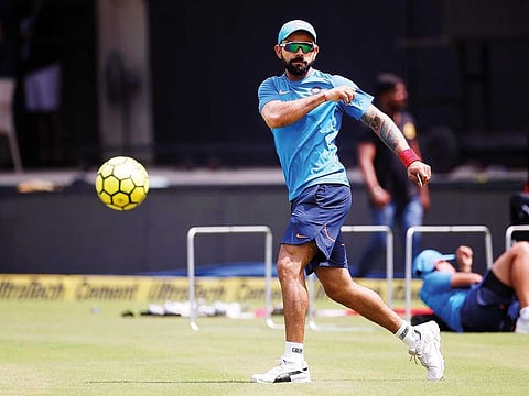 India captain Virat Kohli during a practice session. Inset: Kohli with some of the Indian team members in a photo tweeted by Kohli himself and captioned as ‘Squad 100’. The photo went viral in light of the absence of Rohit Sharma from the snap.