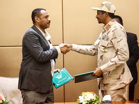 General Mohamed Hamdan Daglo (R), Sudan's deputy head of the Transitional Military Council, and Protest leader Ahmed Rabie shake hands after signing the constitutional declaration at a ceremony attended by African Union and Ethiopian mediators in the capital Khartoum on August 4, 2019.