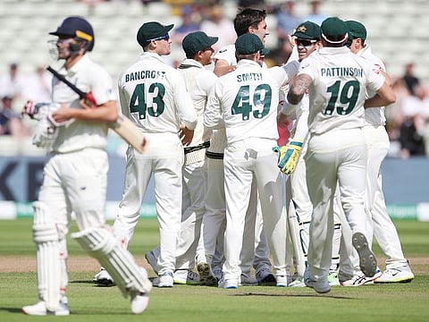 Australia's Nathan Lyon and Pat Cummins celebrate with teammates after taking the wicket of England's Rory Burns during the first Ashes Test match at Edgbaston, in Birmingham, on August 5, 2019 .