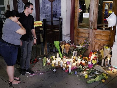Dayton: Mourners visit a makeshift memorial outside Ned Peppers bar following a vigil at the scene of a mass shooting, Sunday, Aug. 4, 2019, in Dayton, Ohio.