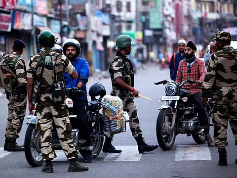 Security personnel question motorists on a street in Jammu on August 5, 2019.