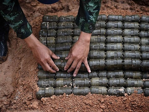 A soldier stacks anti-personnel mines before a controlled detonation at the official Destruction Ceremony of Thailand’s Retained Anti-Personnel Mines 2019 event by the Royal Thai Armed Forces in the western Thai province of Sa Kaeo on August 6, 2019.