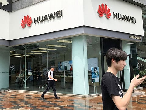 File photo: People walk past a Huawei store in Shenzhen, Guangdong province, China.