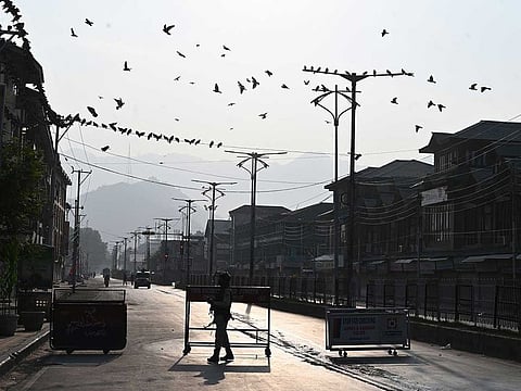 A security personnel stands guard at a roadblock during a curfew in Srinagar on August 6, 2019 - Illustrative image