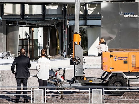 Director of the Tax Agency Merete Agergaard, right, and Minister of Taxation Morten Boedskov view damage caused by an explosion to the entrance of the Danish Tax Authority in Copenhagen, Denmark, Wednesday, Aug. 7, 2019. Police confirm that there was a powerful explosion late Tuesday in front of the Danish Tax Agency in Copenhagen