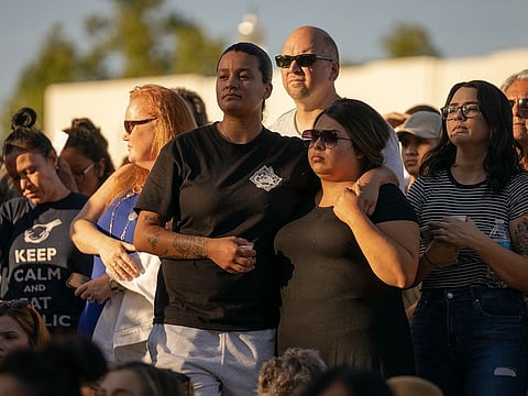 Mourners attend a vigil at the Gilroy Police Department for the victims of the shooting at the Gilroy Garlic Festival in Gilroy, Calif., July 29, 2019.