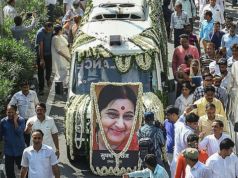 A crowd joins the convoy carrying the mortal remains of former external affairs minister Sushma Swaraj on its way to Lodhi crematorium for her last rites, in New Delhi.