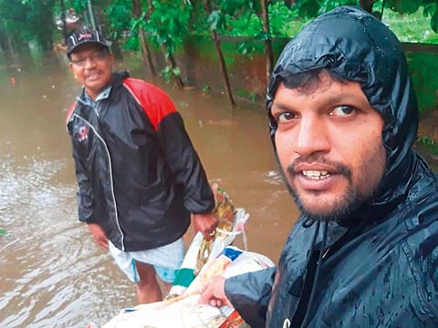 Ryju Perumanna (right), who is on a vacation back home, during flood rescue and relief works in Kerala.