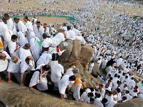 Muslim pilgrims make their way down on a rocky hill known as Mountain of Mercy, on the Plain of Arafat, during the annual Hajj pilgrimage, near the holy city of Makkah, Saudi Arabia, Saturday, August 10, 2019.