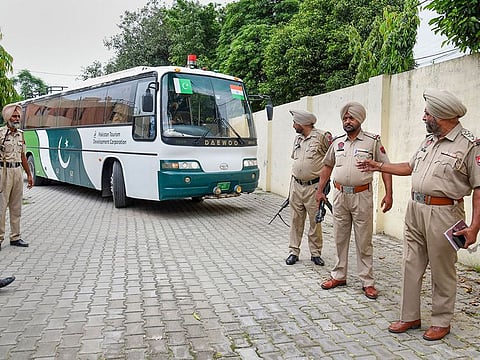 Punjab Police escort a Pakistan Tourism Development Corporation bus as it returns to Lahore without passengers, in Amritsar.