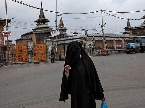 A Kashmiri woman walks past the locked Jamia Masjid during restrictions after the scrapping of the special constitutional status for Kashmir by the government, in Srinagar.