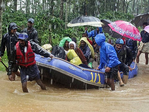 In this Friday, August 9, 2019, photo, Indian army soldiers and volunteers transport flood victims to safer areas in Kodagu dictrict, in the southern Indian state of Karnataka. Flash floods and mudslides caused by days of torrential rains in the southern Indian states of Kerala and Karnataka have forced hundreds of thousands to move to relief camps.