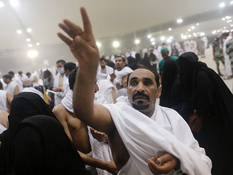 A pilgrim casts stones at a pillar symbolising the stoning of Satan, in a ritual called "Jamarat," the last rite of the annual Hajj.