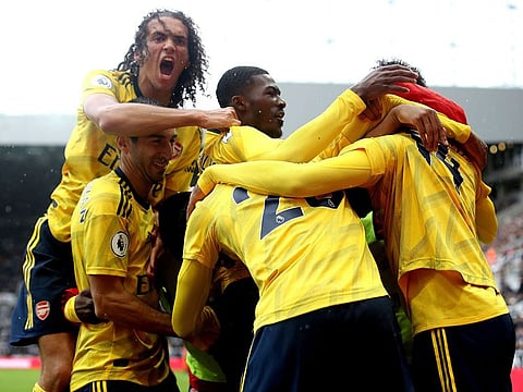 Arsenal's Pierre-Emerick Aubameyang, right, celebrates scoring his side's first goal of the game with his teammates during the English Premier League soccer match between Newcastle United and Arsenal, at St James' Park, in Newcastle, England