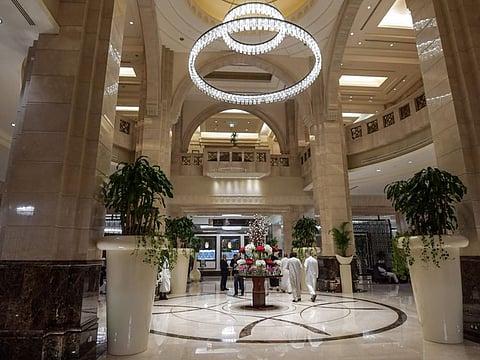 Muslim pilgrims walk through the lobby of a luxury hotel overlooking the Kaaba (the Cube), Islam's holiest shrine, and its encompassing Grand Mosque in Saudi Arabia's holy city of Mecca.