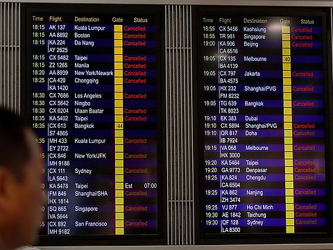 A man looks at the flight information board shows outbound flights was cancel at the Hong Kong International airport.